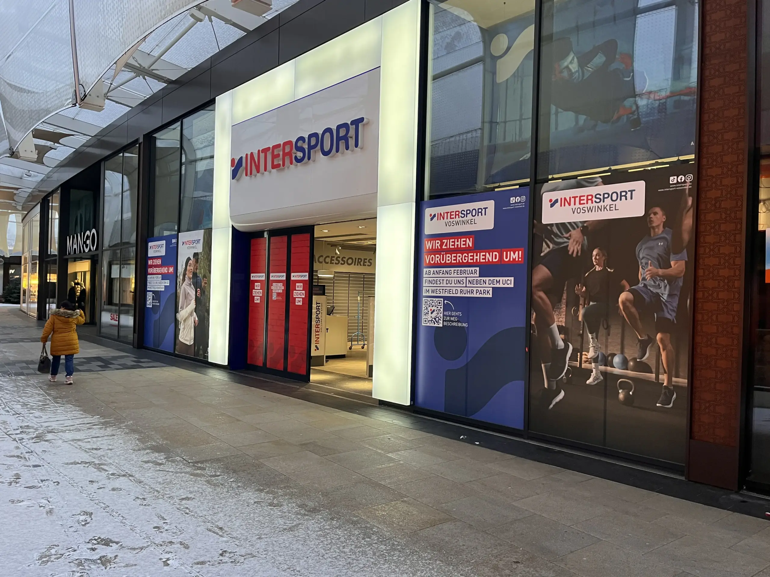 Schaufensterfolierung bei Intersport im Westfield Ruhr Park Bochum Digitaldruck-Sichtschutzfolie auf großer Schaufensterfläche Folierte Glasfront während des Ladenumbaus Schaufensterfolierung als Sichtschutz für ein Ladenlokal Großflächige Digitaldruckfolie auf Schaufenstern Montage einer Schaufensterfolie im Einkaufszentrum Folierte Ladenfront während der Umbauphase Professioneller Sichtschutz auf Glasflächen im Einzelhandel