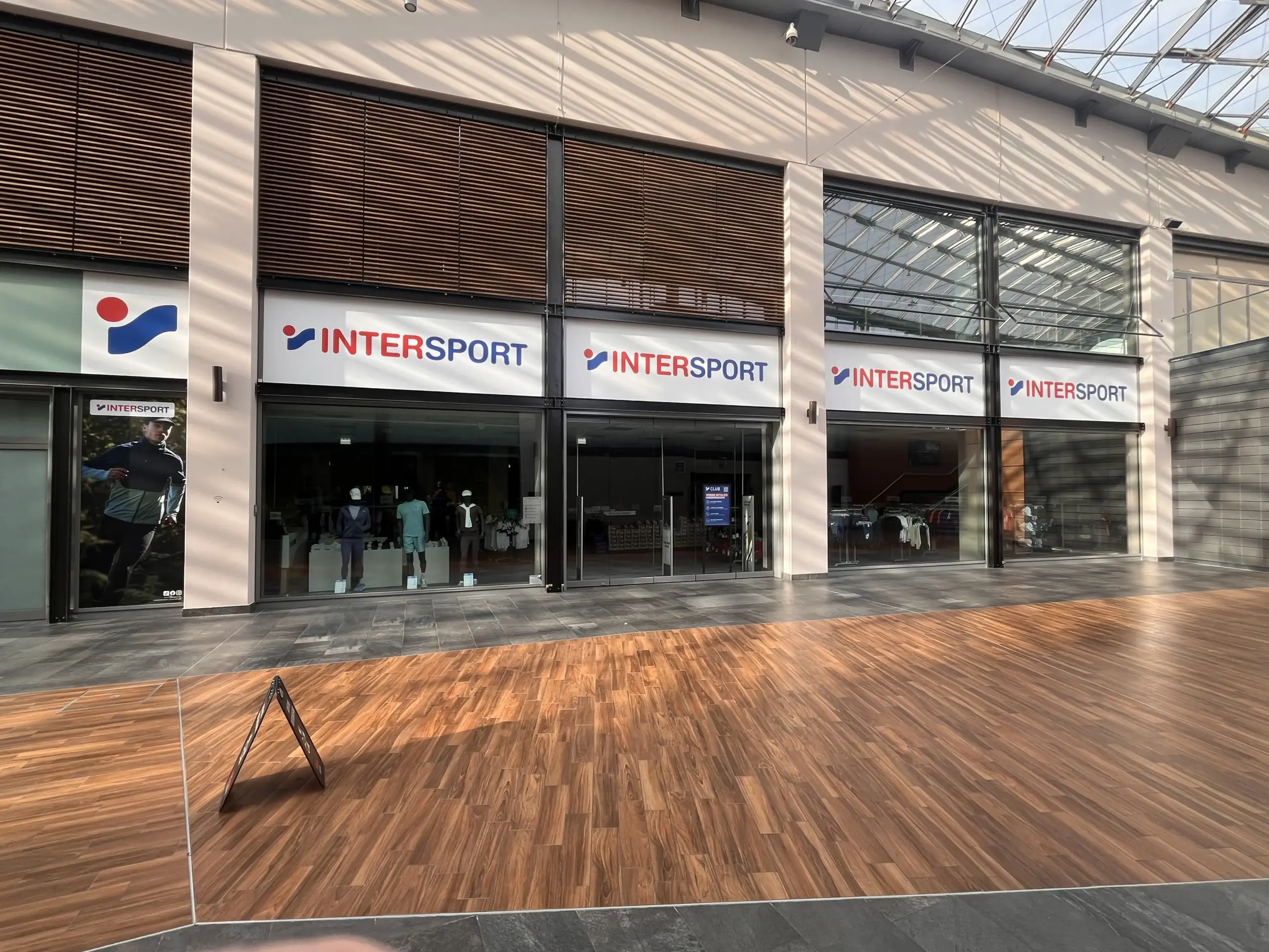 Schaufensterfolierung bei Intersport im Westfield Ruhr Park Bochum Digitaldruck-Sichtschutzfolie auf großer Schaufensterfläche Folierte Glasfront während des Ladenumbaus Schaufensterfolierung als Sichtschutz für ein Ladenlokal Großflächige Digitaldruckfolie auf Schaufenstern Montage einer Schaufensterfolie im Einkaufszentrum Folierte Ladenfront während der Umbauphase Professioneller Sichtschutz auf Glasflächen im Einzelhandel