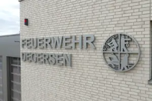 Beschilderung am Neubau der Feuerwehr Degersen Feuerwehr-Logo als Profilbuchstabenanlage in RAL 9006 Profil-1-Buchstaben am Feuerwehrgebäude in Degersen Individuelle Gebäudebeschilderung der Feuerwehr Degersen Leuchtwerbung und Außenbeschilderung am Feuerwehrneubau Piktogramme und Orientierungsschilder im Feuerwehrgebäude Montage der Profilbuchstaben an der Feuerwehr Degersen Fertige Werbetechnik am Neubau der Feuerwehr Degersen